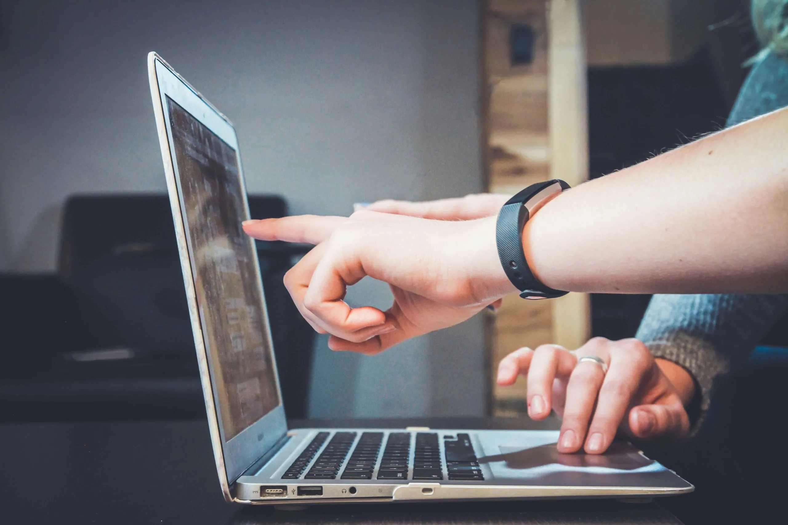 Een vinger wijst naar een website op een laptop