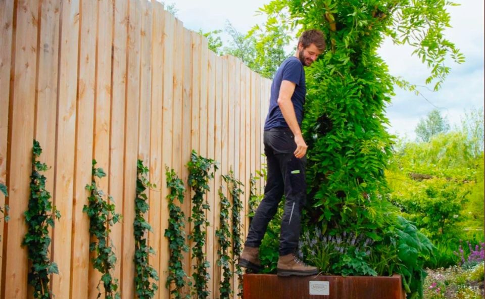 Chris Meeuwsen staat op de plantenbak van een Urban Tree